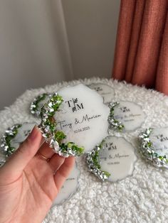 a hand holding a piece of white glass with green leaves on it and the words i'm my mom written on it