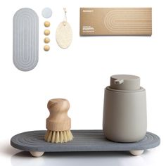 a wooden brush, soap dispenser and other items on a white background