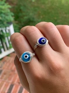 Accessorize with an evil eye wire wrapped ring! These rings are tarnish resistant and will not turn your finger green, making them perfect for everyday wear! The evil eye measures 6mm in diameter. Please message me if you would like a more specific size or need helping finding the correct size for your finger! Evil Eye Rings, Eye Rings, Wire Wrapped Ring, Evil Eye Ring, Wire Wrapped Rings, May 2023, Eye Ring, Blue Band, Wrap Rings