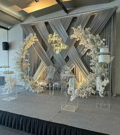 a stage set up with white flowers and chairs