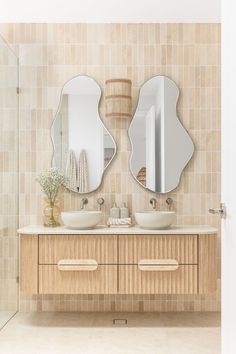 A bathroom features a double vanity with brushed nickel tapware, abstract mirrors and travertine tiles as a feature on the wall behind. Bali Villa, Bath Mirror, Garden Oasis, Family Bathroom, Laundry In Bathroom