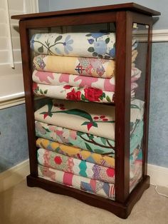 a display case filled with lots of folded fabric