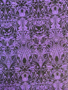 a purple and black wallpaper with skulls on it's back side, as well as an ornate design