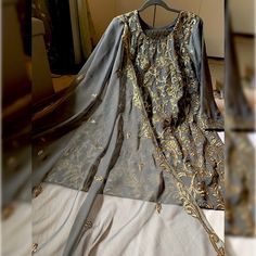 New... Never Worn Before. Gray Color Dress With Golden Work On The Shirt Piece And Duppata. Along With Banarsi Trouser. The Shirt Has Inner Lining Attach With The Kameez. Graceful Attire For Party Or Wedding Wear. Pakistani, Indian, Bangladeshi, South Asian Semi-Casual Party Wear. Measurements Shalwar (Trouser) 38 In Bust 21 Inch Waist 20 In Hips 23 In Shirt Length 37.5 In Sleeves Length 21 In Designer Gray Set With Zari Work, Festive Gray Zari Work Sets, Gray Anarkali Set With Zari Work, Gray Anarkali Set For Festive Occasions, Gray Anarkali Set With Dupatta, Gray Resham Embroidery Kurta For Wedding, Elegant Gray Sets With Zari Work, Festive Gray Sets With Dupatta, Festive Gray Diwali Outfit Sets