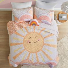 a bed with an orange and pink comforter on top of it next to a white rug