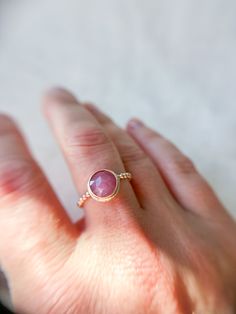 Add a touch of romance to your collection with this enchanting rosecut pink sapphire ring. The gemstone, with its soft, blush-pink hue, catches the light beautifully, revealing subtle facets that glimmer with every movement. Set in a delicate 14k Gold Fill bezel, the sapphire’s gentle color is perfectly complemented by the warm, golden tones of the beaded band, adding a layer of texture and charm. This ring is a perfect blend of feminine elegance and understated luxury, making it an ideal choice Delicate Pink Rings With Rose Cut Diamonds, Pink Sapphire Ring With Bezel Setting For Wedding, Gift Pink Sapphire Ring With Rose Cut Diamonds, Pink Sapphire Ring With Rose Cut Diamonds As Gift, Pink Ruby Ring With Rose Cut Diamonds, Delicate Pink Jewelry With Rose Cut Diamonds, Pink Tourmaline Sapphire Ring As Birthstone, Dainty Pink Jewelry With Rose Cut Diamonds, Dainty Pink Rose Cut Diamond Jewelry