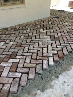 an image of a brick walkway that is being laid on top of the ground in front of a house