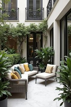 an outdoor living area with couches and potted plants