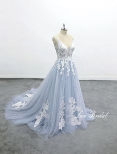 a light blue wedding dress with white flowers on it