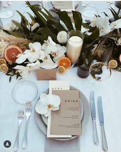 the table is set with silverware and flowers