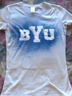 a white tshirt with the letters byu on it sitting on a bed