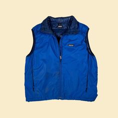 "Vintage puffer vest, manufactured ca. 1990s by Patagonia. This blue zip-up vest features a two-toned blue coloring (dark blue detailing) and two side pockets. Size is not listed, but it fits like a men's M-L - please see measurements and compare to your own.   - Time Period: 1990s  - Brand: Patagonia  - Size: Size not listed; see measurements; fits like a men's M-L  - Colors: Blue (two-toned)  - Materials: Not listed; feels like nylon  - Made in: Tag missing  - Condition: In fair, vintage condi Vintage Puffer Vest, Coloring Dark, 90s Patagonia, Patagonia Puffer, Zip Up Vest, Mens Vests, Vest Outfits, Time Period, Guys Be Like