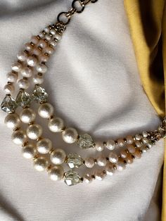 Add a touch of bohemian elegance to your look with this triple-stranded faux beaded pearls necklace. The necklace features an intricate design with beads made of imitation pearls in beautiful ivory colour that gives it a classic look. The necklace is perfect for any occasion and will complement any outfit, be it casual or formal. This necklace is a must-have for any fashion enthusiast and is perfect for those who love to make a statement with their accessories.  Materials: Zinc Alloy, Beads Neck Party Pearl Multi-strand Beaded Necklace, Multi-strand Pearl Beaded Necklace With Faceted Beads, Cream Multi-strand Pearl Necklaces, Elegant Multi-strand Beige Necklace, Cream Pearl Multi-strand Necklace, Cream Pearl Beaded Necklace With Pearl Chain, Cream Pearl Chain Beaded Necklace, Cream Beaded Pearl Necklace For Party, Cream Multi-strand Pearl Necklace