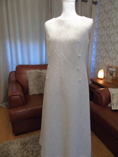 "This is an amazing vintage evening/wedding/cruise/special occasion gown in ivory and silver made by spinney in a crimplene material. Excellent vintage condition size UK 18 on the label. Shoulder to hem 52\" underarm to underam 18.5\"" Vintage A-line Wedding Evening Dress, Vintage Silver Dress For Formal Occasions, Silver Vintage Dress For Formal Occasions, Silver Vintage Dresses For Formal Occasions, Silver Vintage Formal Dresses, Silver Vintage Wedding Dress, Vintage A-line Maxi Dress For Wedding, Vintage White Maxi Dress For Evening, Vintage Silver Wedding Dress