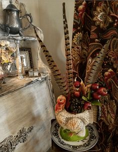 a bird statue sitting on top of a table next to a vase filled with flowers