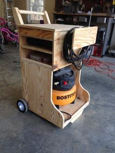 a wooden cart with an electric device in it's center and power cord attached to the top