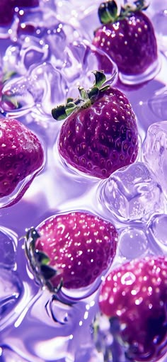 some strawberries are floating in ice cubes on the water and have green leaves