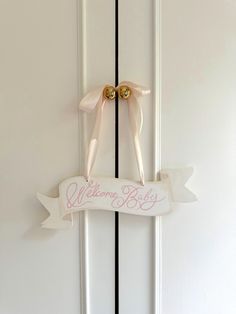 a white door with pink ribbon and two bows on it