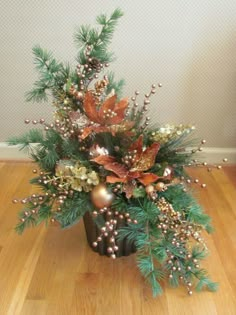 a vase filled with lots of different types of flowers and greenery on top of a wooden floor