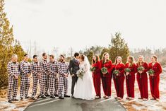 a group of people standing next to each other in front of snow covered ground and trees