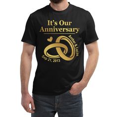 a man wearing a black t - shirt that says it's our anniversary with gold lettering