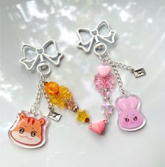 three key chains with charms on them sitting next to each other in the shape of animals