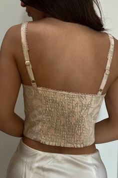 Shine on in this Renaissance-inspired corset top fit for a lady with a pink metallic jacquard finish. Oh, and that lace-up front? To die for. / Lurex jacquard fabric 62% Polyester, 34% Rayon, 4% Lurex Fully linedMicro lace trim at neckline and strapsLace up front detail with metal D ringsUnderwire and boning for supportSmocking at back panel for stretchAdjustable straps Party Lace Top With Corset Back, Party Lace Tops With Boned Bodice, Pink Lace Crop Top For Party, Lace Tops With Corset Back, Party Tops With Lace Trim And Underbust Shape, Pink Metallic, Shine On, A Lady, Jacquard Fabric