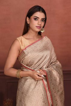 Radiate elegance on festive occasions in this cream golden zari Katan silk Banarasi saree with red edging. It comes with a red blouse piece. Disclaimer: The shown stitched blouse on the model is for display purpose only. The saree comes with a matching blouse piece and finished with fall and piko. Disclaimer: The actual product may vary slightly from the image. These are custom orders, hence expect slight variation in color, placement of the motif or buta. ESTIMATED DELIVERYBecause this is a cus Gold Meenakari Tussar Silk Blouse Piece, Cream Self Design Saree, Cream Self-design Saree, Traditional Beige Saree, Elegant Gold Blouse Piece With Meenakari, Elegant Gold Blouse With Meenakari, Elegant Gold Meenakari Blouse Piece, Beige Traditional Wear With Zari Weaving For Festivals, Traditional Beige Wear With Unstitched Blouse