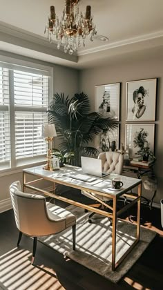 a living room filled with furniture and a chandelier above a glass top table