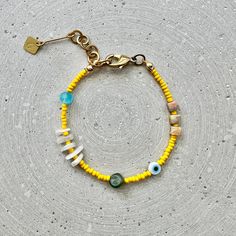 Colorful narrow bead bracelet with agate cubes, moonstone and jade nuggets, as well as yellow and turquoise glass beads and an Evil Eye charm. Perfect for your beach outfit! Matching earrings are also available for this bracelet: https://www.etsy.com/listing/1475446457 LENGTH The total length is approx. 20cm/7.8" and fits best on wrists between 16-18cm/6.3" to 7" thanks to the extension chain. If you need a different length, simply select the "custom length" option in the menu and specify your w Natural Stone Beads Bracelet For Beach, Yellow Beaded Bracelets With Colorful Beads For Beach, Colorful Beaded Bracelets For The Beach, Yellow Beaded Bracelets For Beach With Colorful Beads, Adjustable Yellow Beaded Bracelets With Natural Stones, Yellow Bracelets With Colorful Beads, Yellow Bracelets With Colorful Round Beads, Handmade Yellow Heishi Beads Jewelry, Yellow Bohemian Beaded Bracelets With Gemstones