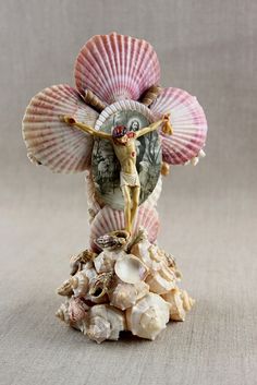 a figurine with shells on the bottom and an image of a woman's head