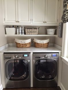 a washer and dryer in a laundry room with cabinets above the washer