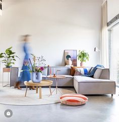 a living room filled with furniture and plants