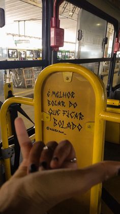 a person's hand on the back of a yellow bus