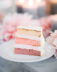 a piece of cake sitting on top of a white plate next to pink and white flowers