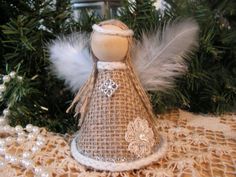 an angel ornament sitting on top of a table next to a christmas tree