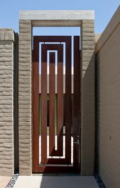 an entrance to a house with a wooden door and brick wall in the back ground