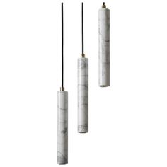 three white marble pendants hanging from black cords on a white background with one light in the middle