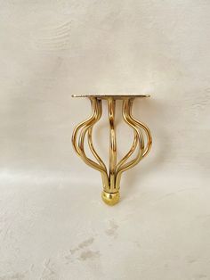 a gold plated metal object on a white surface with no one around it or someone else