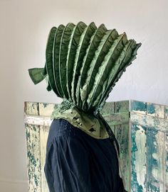 A delightful large antique calash bonnet. Green silk fabric over ribs with a semi-sheer lining and buckram at crown. Ruffle around face and a bow at the back of crown. Ten ribs including front brim. Collapsible bonnet that lays flat. Completely hand stitched. Fair condition with soiling, exposed ribs, fragile damaged neck apron, and fabric wear as seen in photos. Laying flat it measures 13" x 11" plus neck apron. Opened it is approximately 15" x 13" x 11". Dates to late 18th century to early 19th century. Green Silk Fabric, Hair Adornments, Bonnet Hat, Current Fashion, Jane Eyre, Green Silk, Paper Design, Hat Hairstyles, Hand Stitched