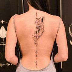 the back of a woman's neck with a fox and arrow tattoo on it