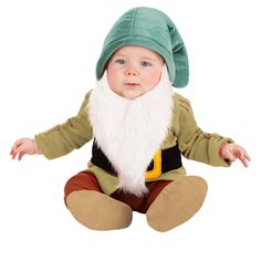 a baby dressed up as an elf sitting on the floor with his hands in his pockets