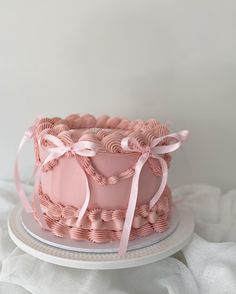 a pink cake sitting on top of a white plate