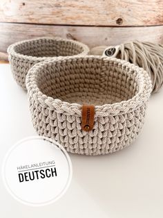 two crocheted baskets sitting on top of a white table