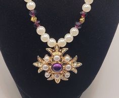 "Totally Royal  Gorgeous purple glass stone with small pearls. Necklace carries on the theme with gold, purple and pearl beads.  Necklace measures 18\"." Purple Jewelry For Mardi Gras, Purple Pearl Jewelry For Formal Occasions, Purple Pearl Formal Jewelry, Purple Pearl Drop Necklaces, Purple Pearl Necklace With Pearl Pendant, Formal Purple Pearl Jewelry, Purple Pearl Jewelry For Party, Purple Pearl Pendant Jewelry, Purple Pearl Drop Jewelry