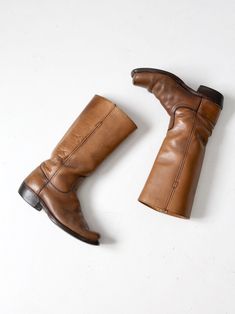 "This is a pair of vintage Frye campus boots. The classic tall boot features beautifully aged saddle brown leather with a wood stacked heel. CONDITION In good condition with wear consistent with age and use. General scuffs and scratches on the leather and soles. Some water spots on one boot inner leg. MARKED SIZE: 7.5 D US Women's Size: 9 MEASUREMENTS Height: 14\" .. 35.6 cm Wall to Toe Length: 11\" .. 27.9 cm Sole Width: 4\" .. 10.2 cm Circumference at Top: 14.75\" ... 37.5 cm Heel Height: 1.5\ Vintage Leather Moto Boots For Fall, Classic Vintage Brown Boots For Fall, Vintage Moto Boots With Snip Toe And Leather Lining, Vintage Snip Toe Moto Boots With Leather Lining, Classic Brown Knee-high Moto Boots, Vintage Brown Moto Boots With Leather Lining, Vintage Distressed Brown Moto Boots With Round Toe, Vintage Fall Moto Boots With Leather Lining, Classic Distressed Brown Boots For Fall