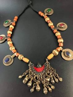 Amazing, Pakistani necklace with a metal medallion in the color of old gold. The chain is made of wooden and fabric beads. Original Pakistani rupees decorated with stones in the colors of navy blue(lapos lazuli), red and green look beautiful. Length 33 cm, medallion 5 cm x 8 cm. Traditional Handmade Medallion Coin Necklace, Traditional Medallion Necklace With Antique Finish, Handmade Traditional Coin Necklace, Pakistani Rupees, Traditional Coin Necklaces For Collectors, Antique Necklaces With Coin-shaped Large Pendant, Pakistani Necklace, Jewelry Traditional, European Jewelry