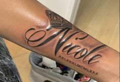 a person with a tattoo on their arm and the word name nicole written in cursive writing