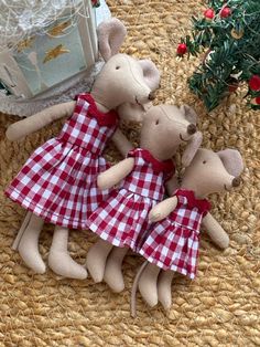 three teddy bears dressed in red and white checkered dresses