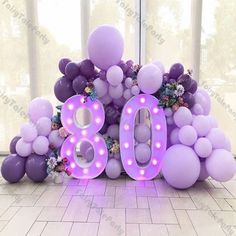 the balloon letters are purple and white with flowers on them for an 80th birthday party